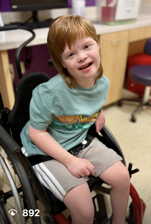 Micah smiling while seated in his wheelchair